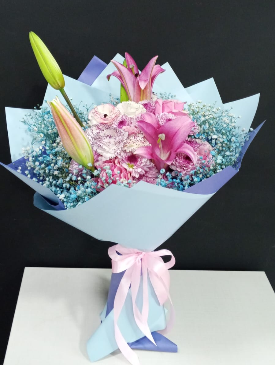 Pink lilies, carnations and ranunculus with blue baby's breath